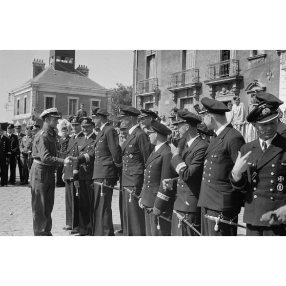 A l'issue de sa 5e mission en mer à bord du sous-marin U-552, le lieutenant (Oberleutnant zur See) Erich Topp salue des autorités de la Kriegsmarine rassemblées sur le quai du port de Saint-Nazaire.