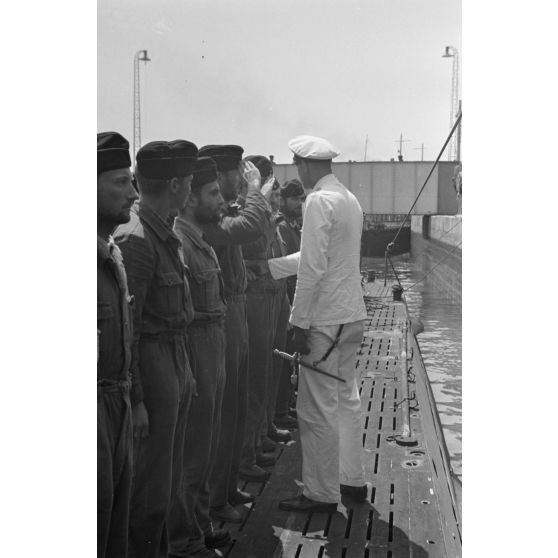 Sur le pont du sous-marin U-boot U-75, le capitaine (kapitänleutnant) Herbert Sohler, représentant de la 7.Unterseebootsflottille, passe en revue l'équipage.
