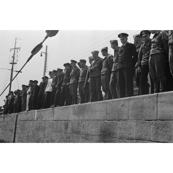 Lors du retour de croisière du sous-marin U-75, des marins, des aviateurs et des infirmières se pressent sur le quai du port de Saint-Nazaire.