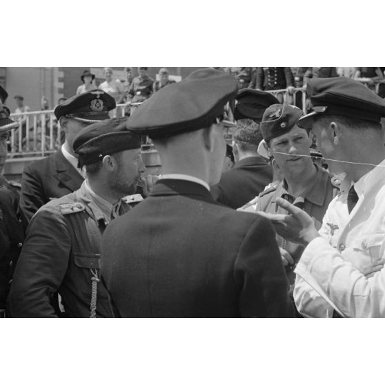Des officiers de la 7.Unterseebootsflottille se pressent autour du Kapitänleutnant Helmuth Ringelmann peu après son retour de croisière au port de Saint-Nazaire.