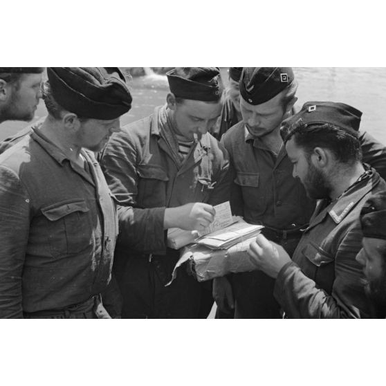 Des sous-mariniers du U-boot U-75 découvrent leur courrier, peu après leur de retour de croisière au port de Saint-Nazaire.