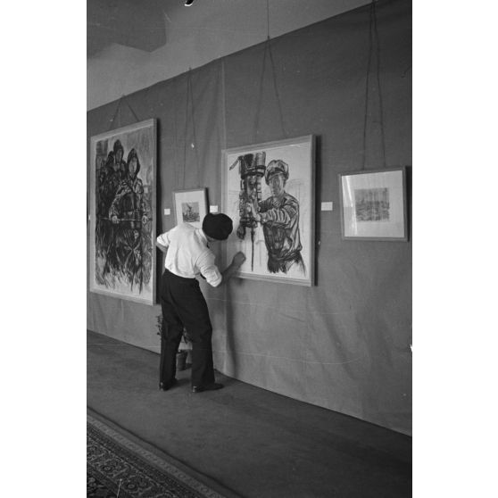 Dernières retouches avant l'inauguration d'une exposition de dessins et de peinture réalisés par les reporters et peintres de guerre (Kriegsmaler) Lothar-Günther Buchheim et Richard Schreiber.
