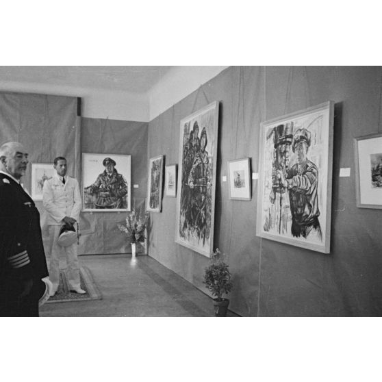 Le capitaine de corvette (Korvettenkapitän) Adalbert Zuckschwerdt lors de l'inauguration d'une exposition de dessins réalisés par les peintres de guerre (Kriegsmaler) Lothar-Günther Buchheim et Richard Schreiber.