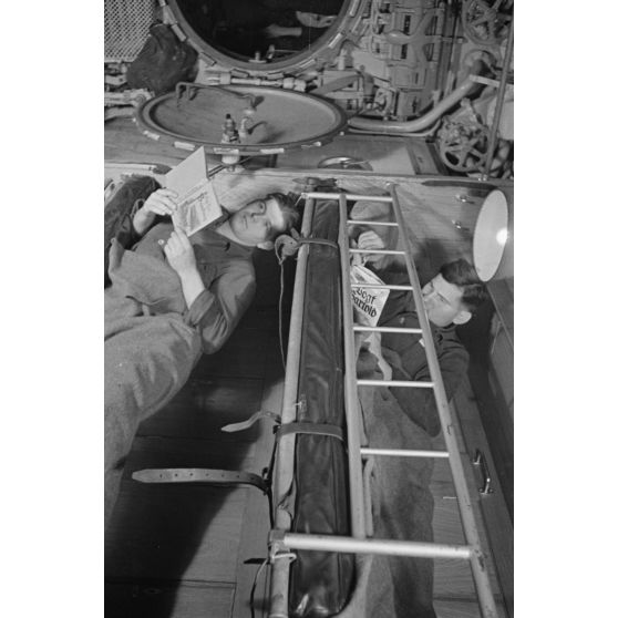A bord d'un U-boot, dans le cadre de la semaine du livre allemand, des sous-mariniers allemands parcourent des ouvrages allongés sur une couchette.
