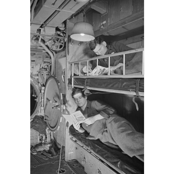 A bord d'un U-boot, dans le cadre de la semaine du livre allemand, des sous-mariniers allemands parcourent des ouvrages allongés sur une couchette.