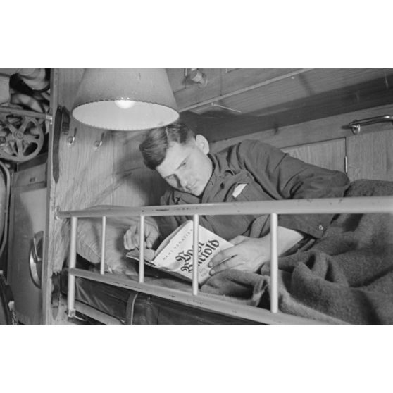 A bord d'un U-boot, dans le cadre de la semaine du livre allemand, des sous-mariniers allemands parcourent des ouvrages allongés sur une couchette.