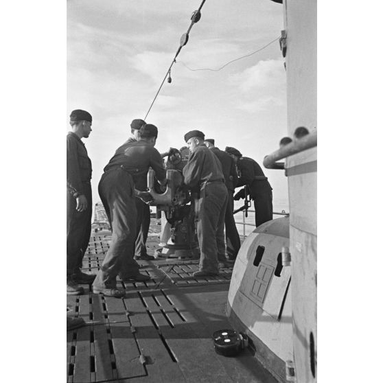 A bord d'un sous-marin allemand (U-boot), les sous-mariniers s'exercent au canon de 10,5 cm SK C/32 (Schnellladekanone - canon à chargement rapide).