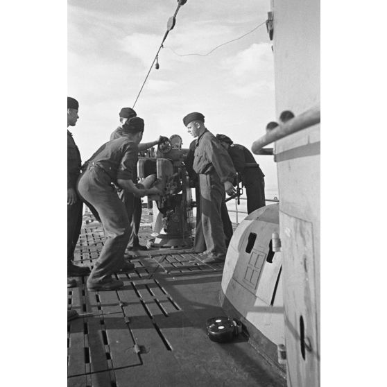 A bord d'un sous-marin allemand (U-boot), les sous-mariniers s'exercent au canon de 10,5 cm SK C/32 (Schnellladekanone - canon à chargement rapide).