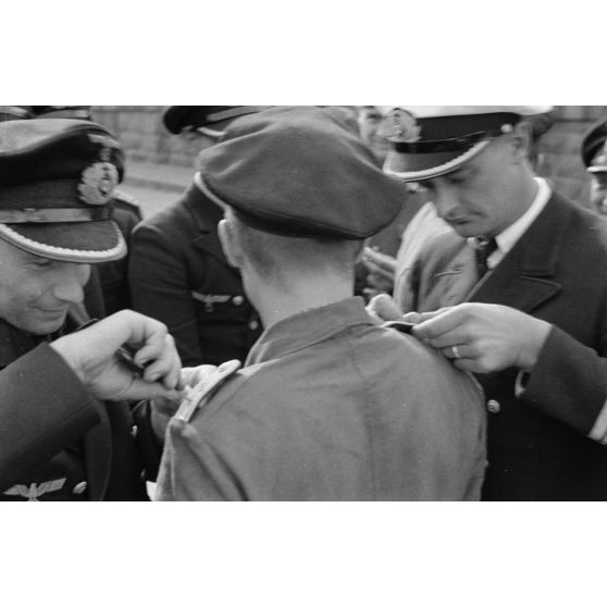 Sur le quai du port de Saint-Nazaire, un officier, membre de l'équipage d'un U-boot, reçoit les pattes d'épaule d'Oberleutnant zur See suite à une promotion.