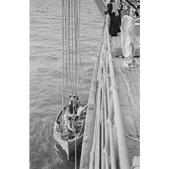 Une barque et ses passagers sont montés à bord du mouilleur de mines Ostmark.