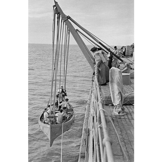 Une barque et ses passagers sont montés à bord du mouilleur de mines Ostmark.