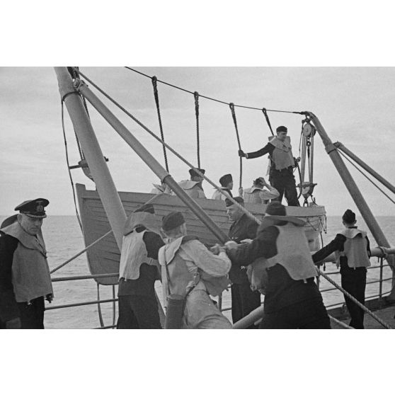 Une barque et ses passagers sont montés à bord du mouilleur de mines Ostmark.