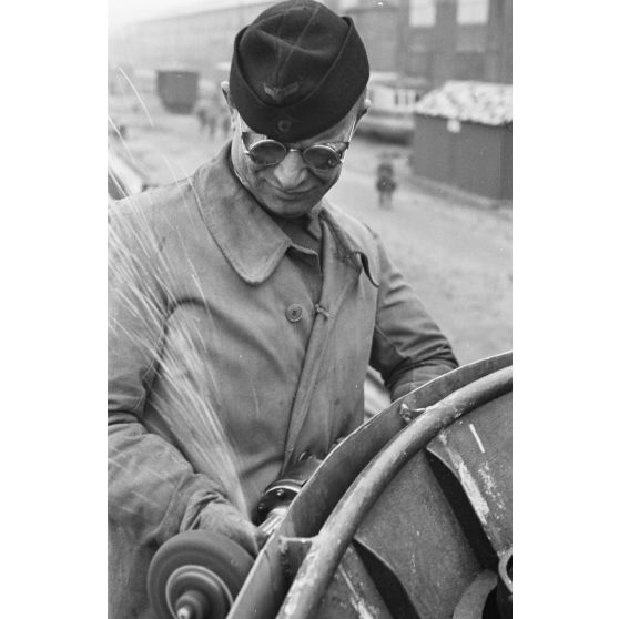 Portrait d'un marin effectuant une réparation sur un sous-marin allemand U-boot, l'ouvrier se focalise sur le kiosque du submersible.