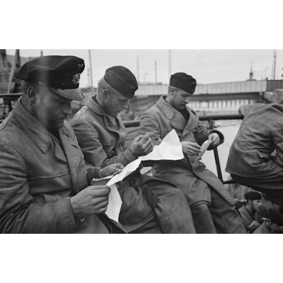 A Saint-Nazaire, à peine de retour de croisière, des sous-mariniers allemands parcourent la presse ou le courrier reçus pendant la mission.