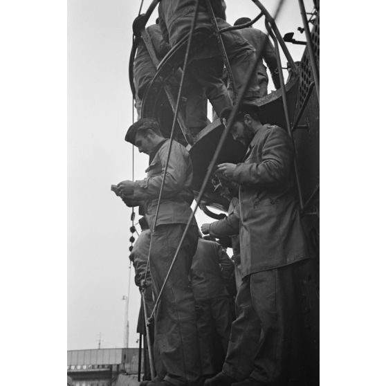 A Saint-Nazaire, à peine de retour de croisière, des sous-mariniers allemands parcourent la presse ou le courrier reçus pendant la mission.