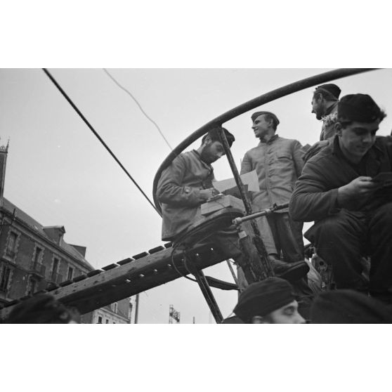 A Saint-Nazaire, à peine de retour de croisière, des sous-mariniers allemands parcourent la presse ou le courrier reçus pendant la mission.