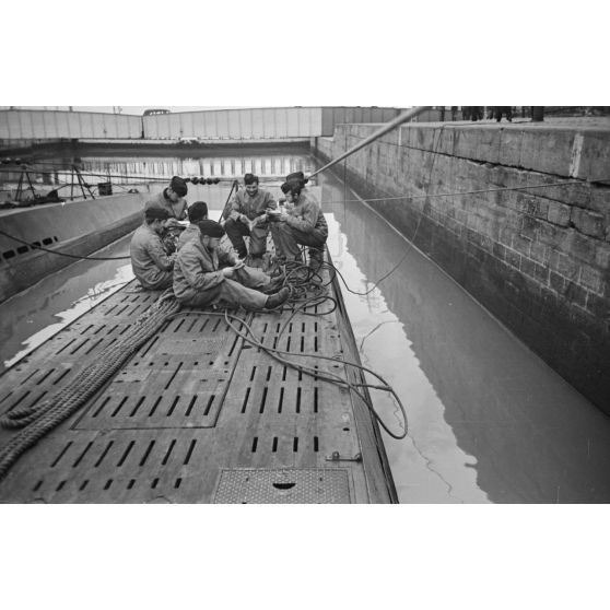 A Saint-Nazaire, à peine de retour de croisière, des sous-mariniers allemands parcourent la presse ou le courrier reçus pendant la mission.