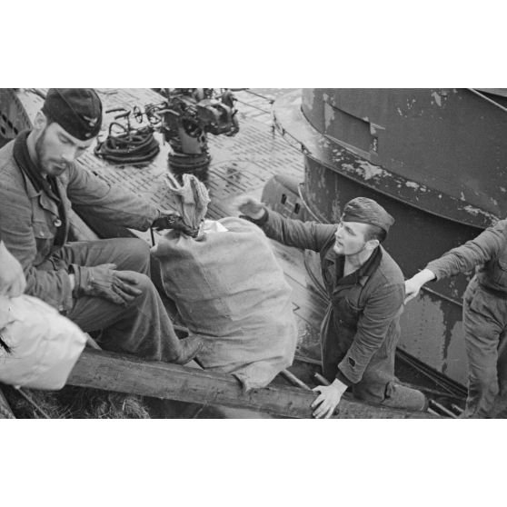 Des membres de l'équipage du sous-marin U-93 déchargent des affaires peu après leur retour au port de Saint-Nazaire.