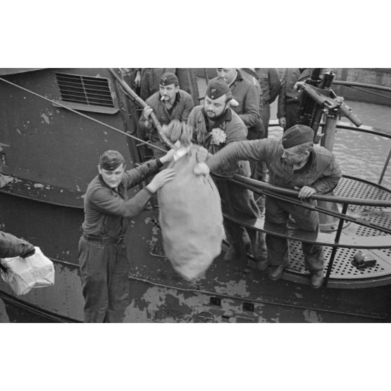 Des membres de l'équipage du sous-marin U-93 déchargent des affaires peu après leur retour au port de Saint-Nazaire.