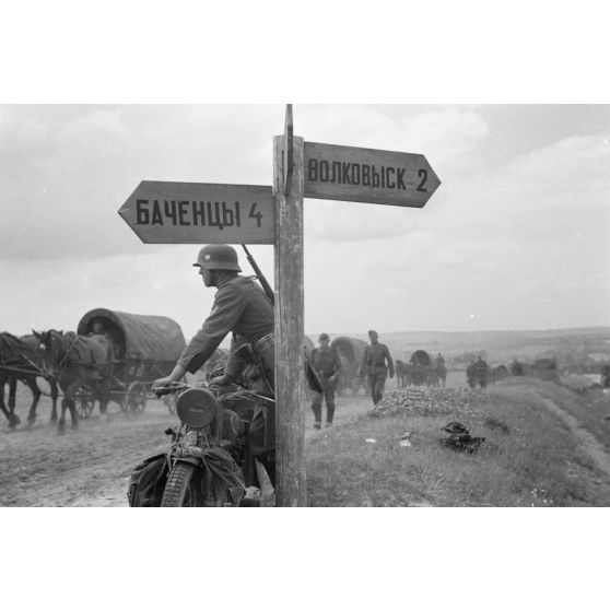 En Biélorussie, un panneau indique les destinations suivantes Bachentsi (БАЧЕÐЦЫ) et Volkovysk (Волковыск).