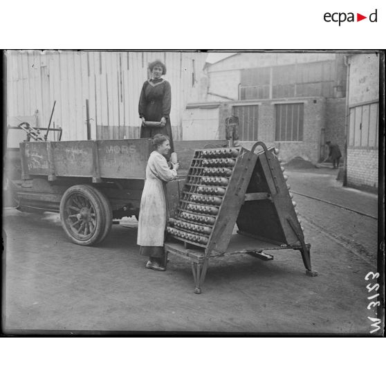 Paris, usine Citroën du quai de Javel. Femme de l'usine transportant des obus. [légende d'origine]