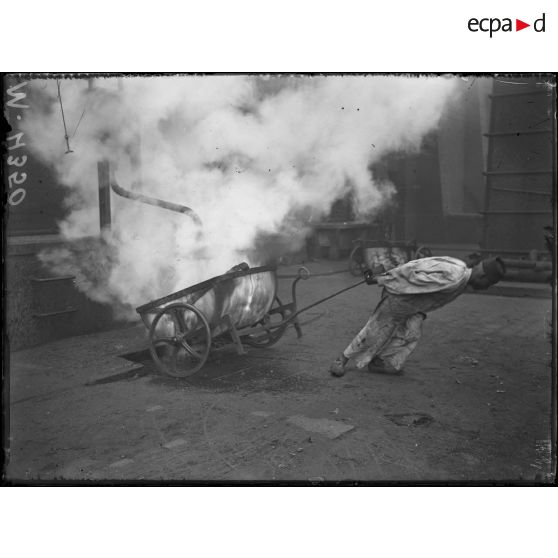 Usine à gaz à Clichy. Le coke à la sortie des cornues est transporté sous un cabinet d'eau. [légende d'origine]