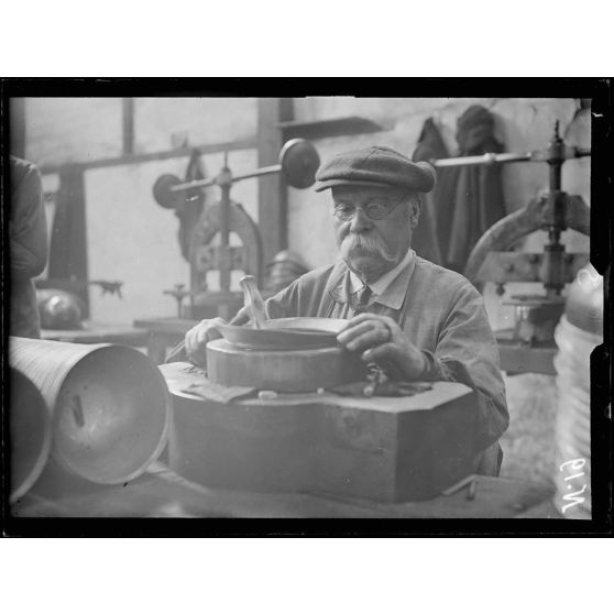 Paris. Usine Simon, 120 boulevard Mortier. Les différentes phases de la fabrication des casques. Agraffage de la visière et du couvre-nuque. [légende d'origine]