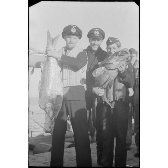 Des marins allemands de la 12. Räumbootflottille présentent le résultat de la pêche.