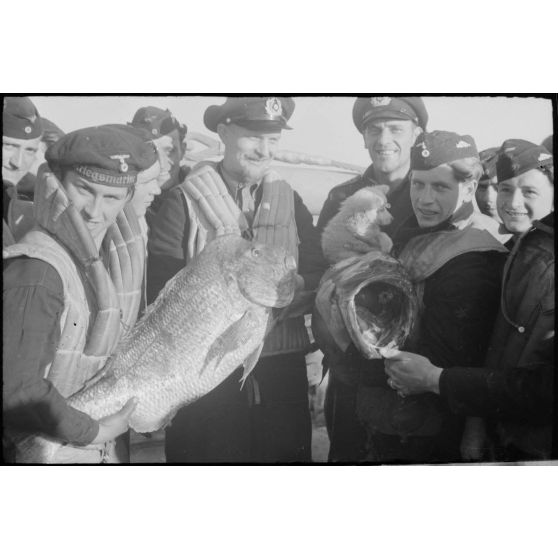 Des marins allemands de la 12. Räumbootflottille présentent le résultat de la pêche.