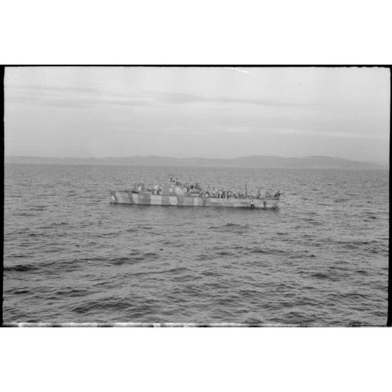 Un dragueur de mines de la 12.Räumbootsflottille, un insigne est visible sur la proue du bâtiment.