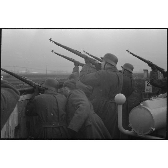 Au sein d'une batterie de 8,8 cm FlaK, les servants d'un télémètre (Kommandogerät 36) apportent leur appui feu à l'aide de fusil Mauser 98k.