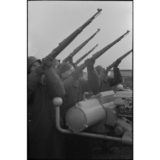 Au sein d'une batterie de 8,8 cm FlaK, les servants d'un télémètre (Kommandogerät 36) apportent leur appui feu à l'aide de fusil Mauser 98k.