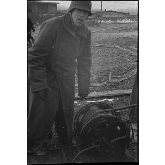 Un artilleur de la FlaK va déployer le câble qui relie et alime les différents organes de visée.