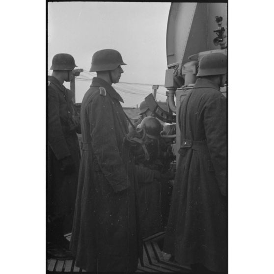 Au sein d'une batterie de 8,8 cm FLaK, des artilleurs de l'armée de l'air allemande derrière un radar Wurzburg.