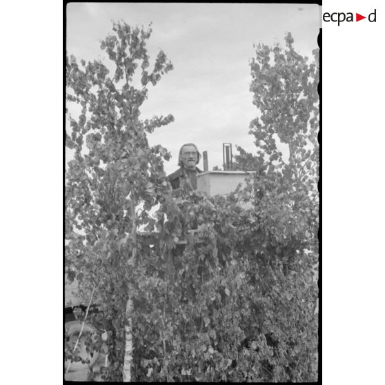 Un pope prononce un discours à une tribune, peu avant le défilé des volontaires sous l'uniforme allemand.