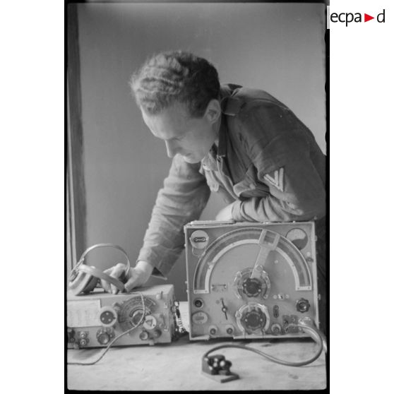Un caporal-chef (Obergefreiter) se penche sur un poste radio allemand.