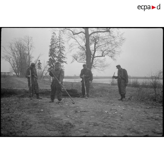 Des fantassins ou des pionniers fouillent le sol  à l'aide de détecteur de mines (Minensuchgerät 41).