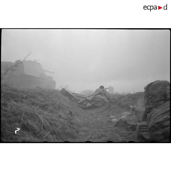 Un Nashorn du schwere Panzer Abteilung 519 tire, des fantassins restent en contre-bas.