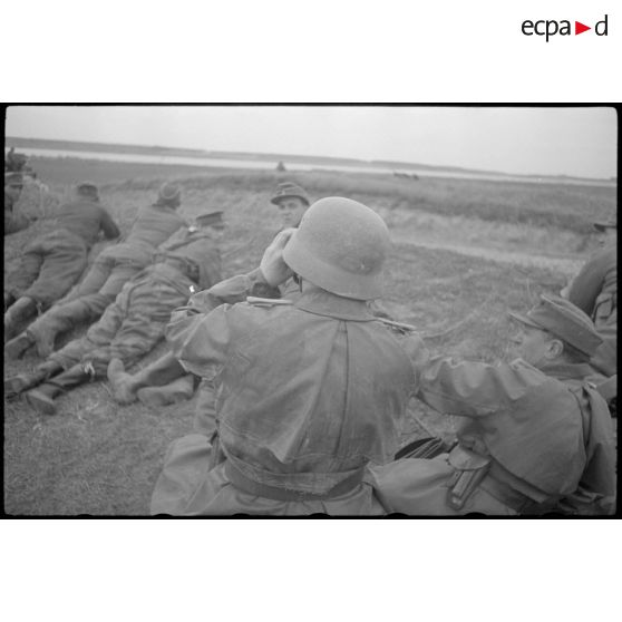 Un lieutenant de la Pk.697, casqué et portant un imperméable, s'est placé à la gauche d'un colonel de l'infanterie.