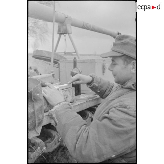 Un membre d'équipage du Schwere Panzer Abteilung 519 mange sur le châssis du char.