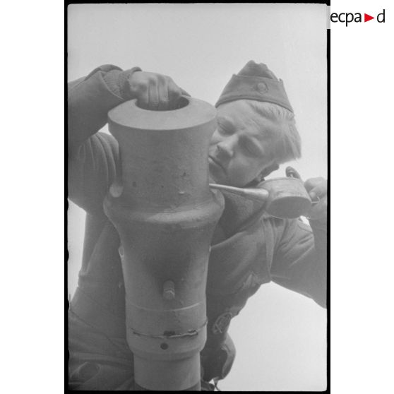 Au sein du Schwere Panzer Abteilung 519, un manque d'équipage d'un Nashorn effectue la maintenance du canon de 8,8 cm.