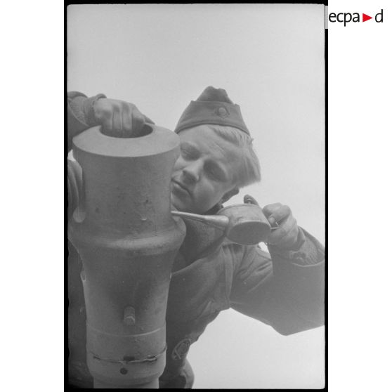 Au sein du Schwere Panzer Abteilung 519, un manque d'équipage d'un Nashorn effectue la maintenance du canon de 8,8 cm.