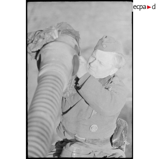 Au sein du Schwere Panzer Abteilung 519, un manque d'équipage d'un Nashorn effectue la maintenance du canon de 8,8 cm.