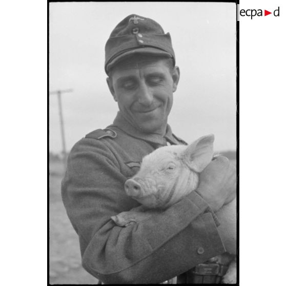 Portrait d'un soldat portant dans ses bras un porcelet.
