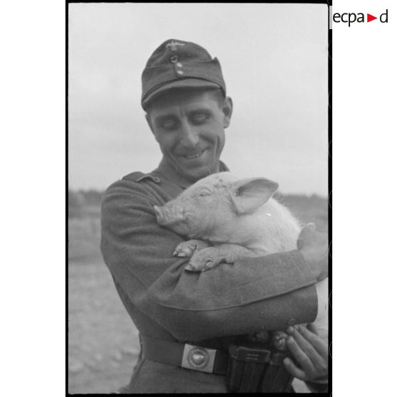 Portrait d'un soldat portant dans ses bras un porcelet.