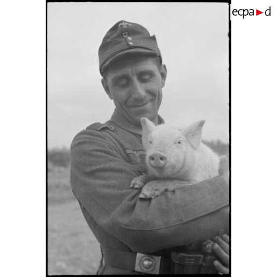 Portrait d'un soldat portant dans ses bras un porcelet.