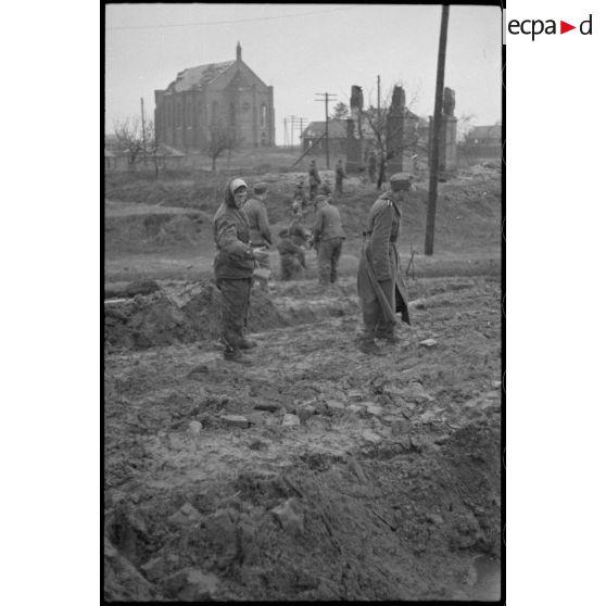 Des fantassins allemandes récupèrent des briques pour renforcer la route devenue impraticable.