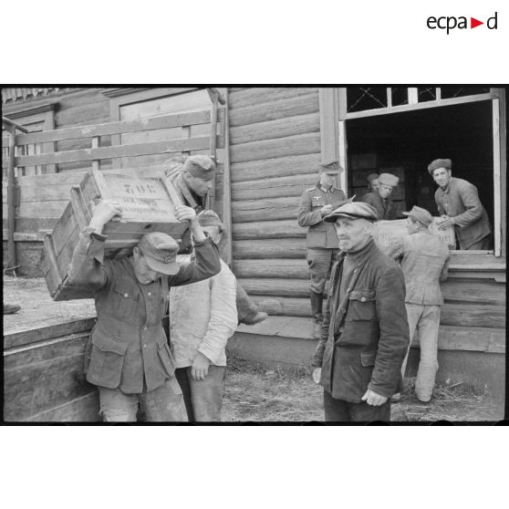 Déchargement de camions par des soldats allemands et des civils requis.