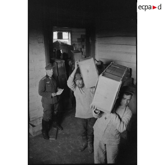 Déchargement de camions par des soldats allemands et des civils requis.