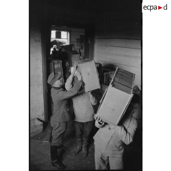 Déchargement de camions par des soldats allemands et des civils requis.